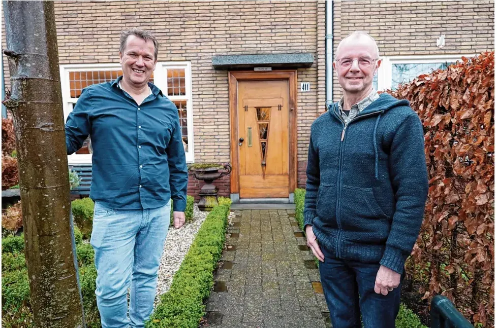 Otto Louwers en Machiel Kneppers voor een woning in de Franklinbuurt, met op de achtergrond een houten Berlage-voordeur