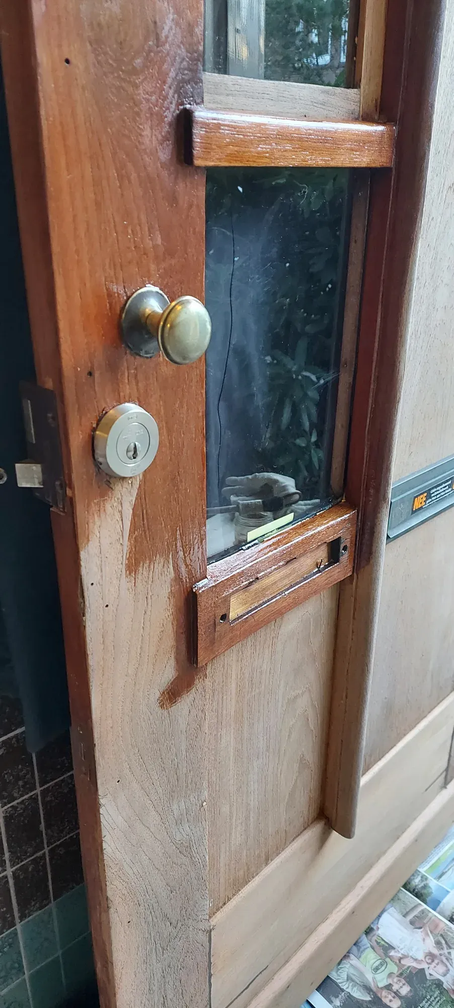 De deur half ontdaan van verf, het hout komt tevoorschijn